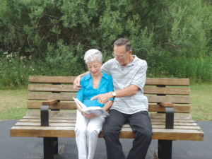 A resident at Eden Heights of West Seneca in Buffalo looks through a photo album with a visitor.