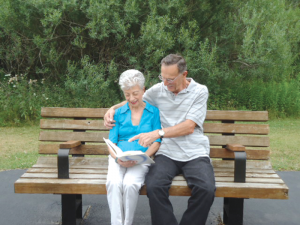 A resident at Eden Heights of West Seneca in Buffalo looks through a photo album with a visitor. 