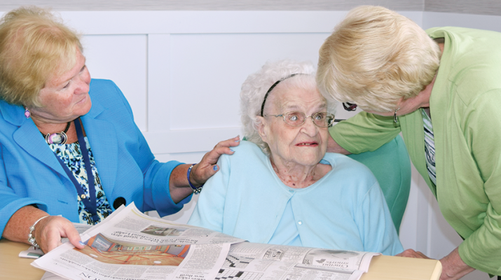 Pictured from left are Cheryl O’Brien, director of social services at Elderwood at Amherst; resident Edith Sawicki and her daughter, Gail Bolster, discussing articles in the daily newspaper.