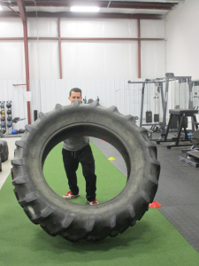 Impact Fitness in Hamburg offers a variety of option for exercise and fitness, including battle ropes, Jacob’s ladder and tire-flipping. Shown is strength trainer Chris Cammarata demonstrating tire flipping. 