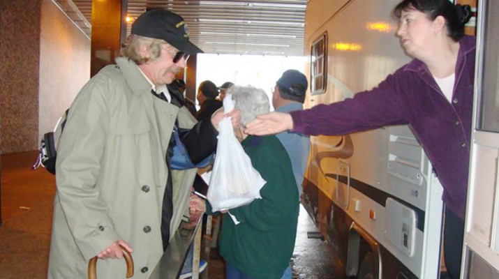 Line of people getting a hot meal at Hearts for the Homeless’ mobile soup kitchen.