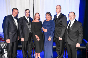 Honored for their distinguished service during Springfest 2019 are physician Thom R. Loree, (second from left); dentist Maureen Sullivan, (third from left); nurse Donna Oddo, (third from right); and Jim Kelly (second from right). Posing with the honorees are ECMC Corp. President & CEO Thomas J. Quatroche Jr., (left) and ECMC Corp. Board of Directors Chairman Jonathan A. Dandes (right). 