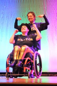 Samantha Hughes celebrates her mastery of her dance number as volunteer Mariah Haddad directs the crowd’s applause in Samantha’s attention.