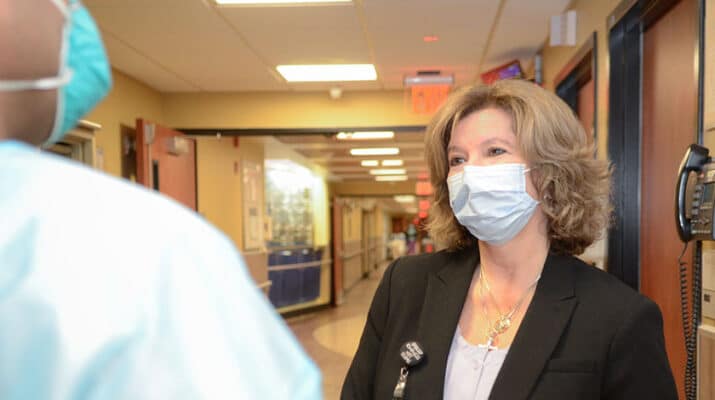 Angela Vacanti, an infection prevention practitioner at ECMC, talks to a colleague at the hospital. “There were times my kids would go to bed and they’d get up in the morning and I’d still be up working,” she says.