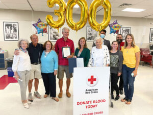 Gene Baran, wearing a red shirt, was honored by the American Red Cross for his consistent blood donations.