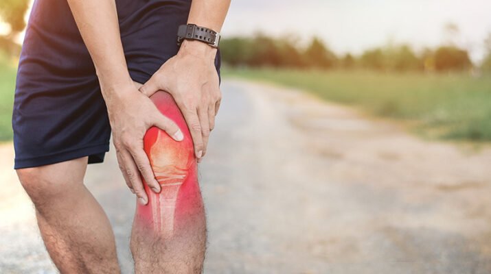 man holding left knee